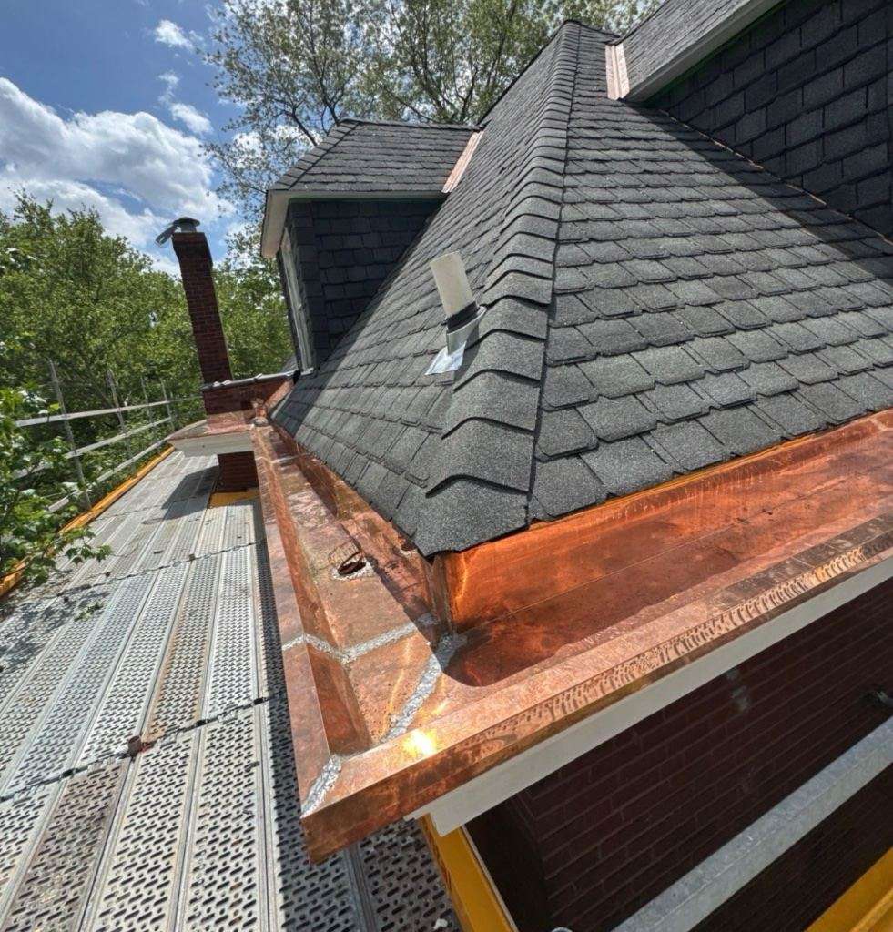 Close view of copper valley flashing beside new shingles