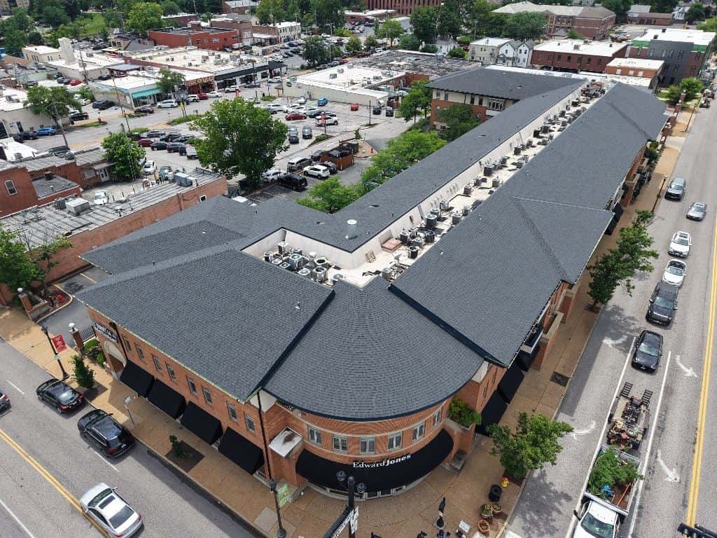 Aerial view of a new shingle roof on a brick retail and office building