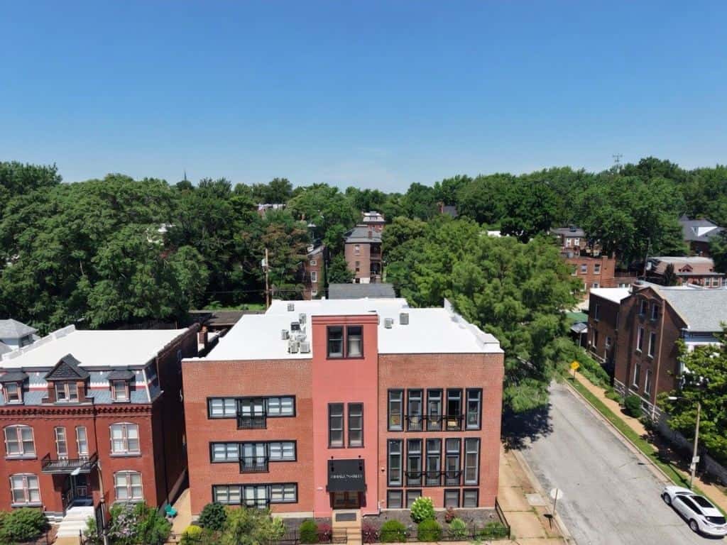 Brick apartment building with a white membrane flat roof