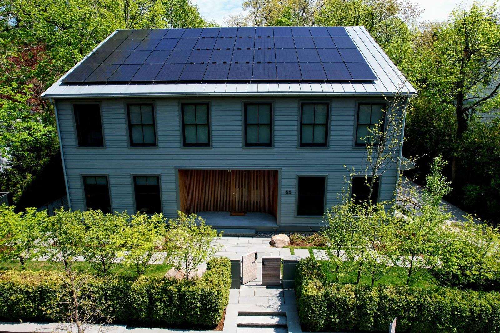 Farmhouse with an all-black solar array across the roof