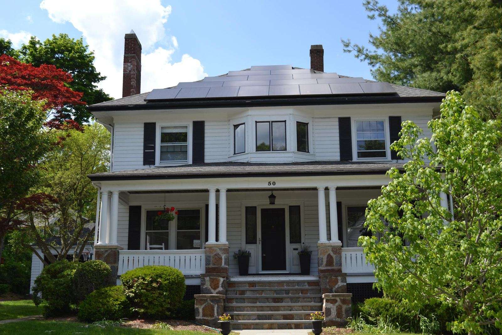 White foursquare home with all-black solar panels
