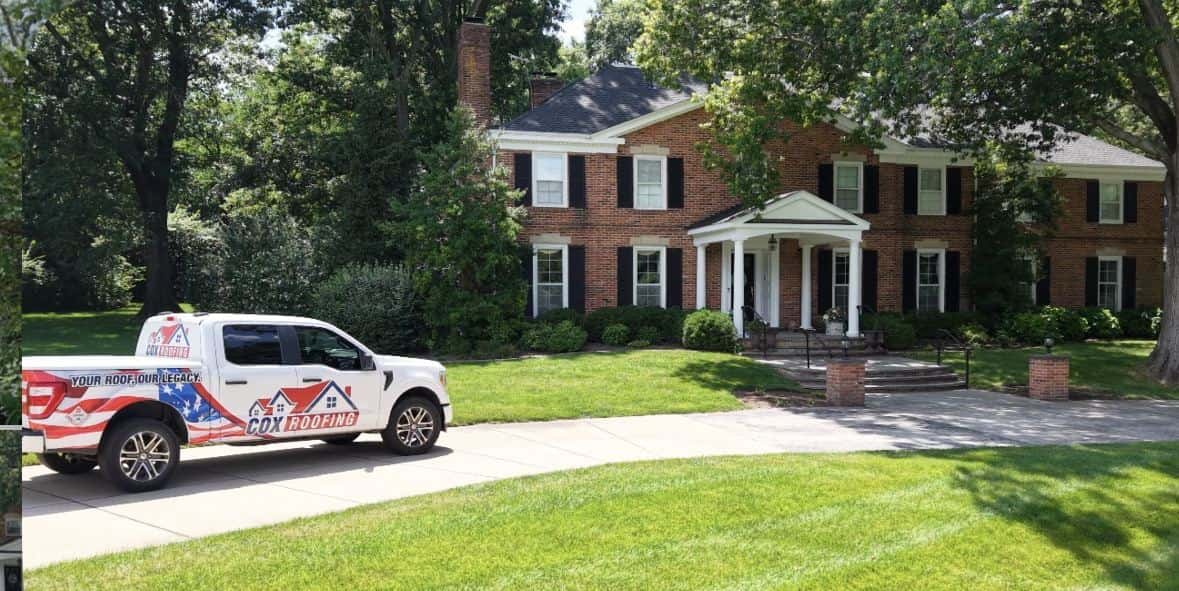 Cox Roofing truck parked in front of a brick colonial home