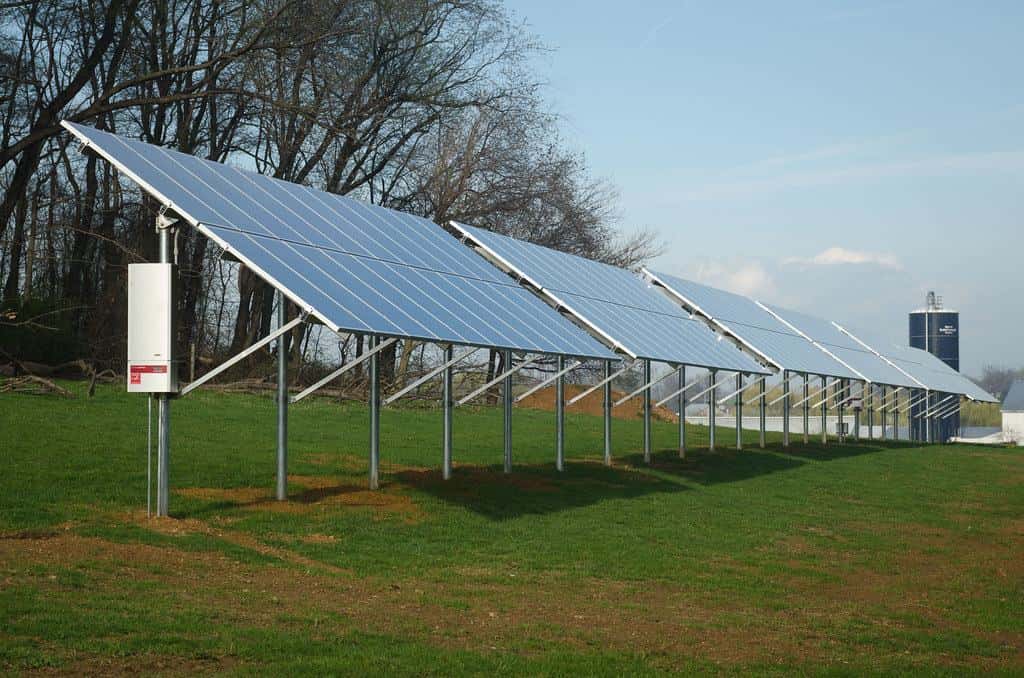 Ground-mounted solar array on steel posts in a grassy field